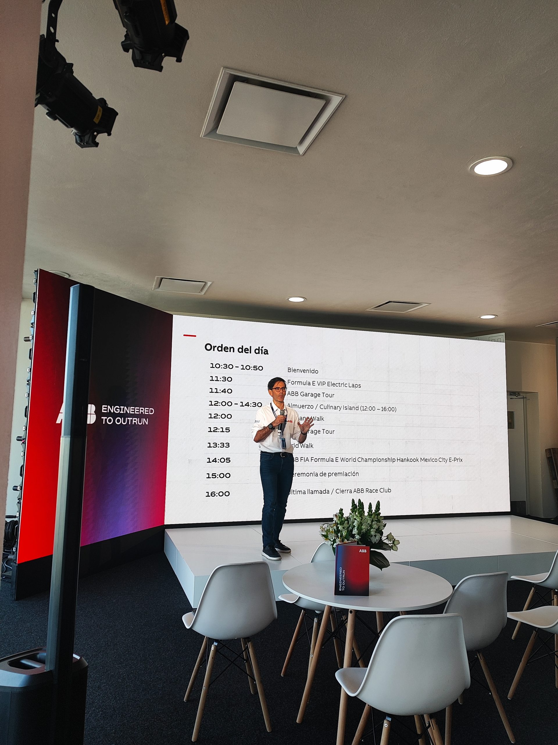 Presentación en vivo dentro de la suite VIP, con LED wall mostrando el orden del día y branding de ABB.